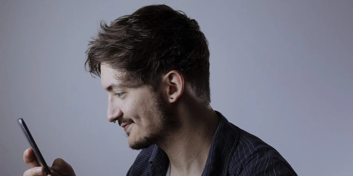 profilo-ragazzo-guarda-cellulare
