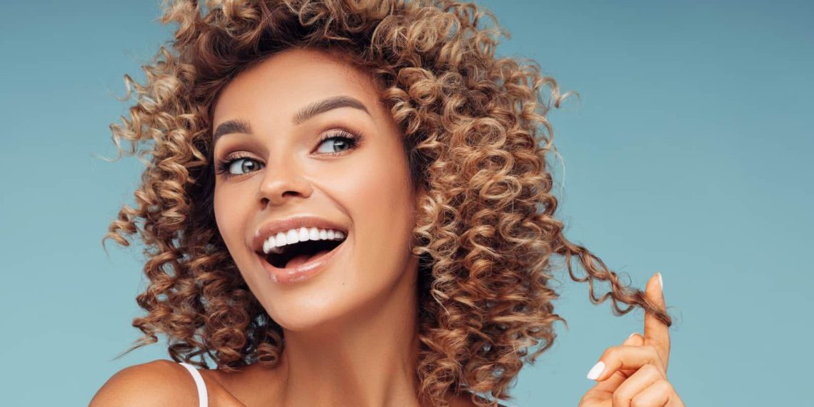 ragazza-contenta-tocca-i-suoi-capelli-ricci