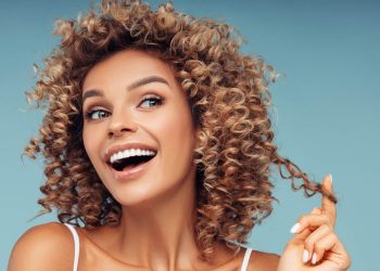 ragazza-contenta-tocca-i-suoi-capelli-ricci