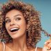 ragazza-contenta-tocca-i-suoi-capelli-ricci